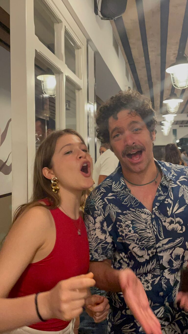 A student and a trainer singing at dinner in a pizzeria