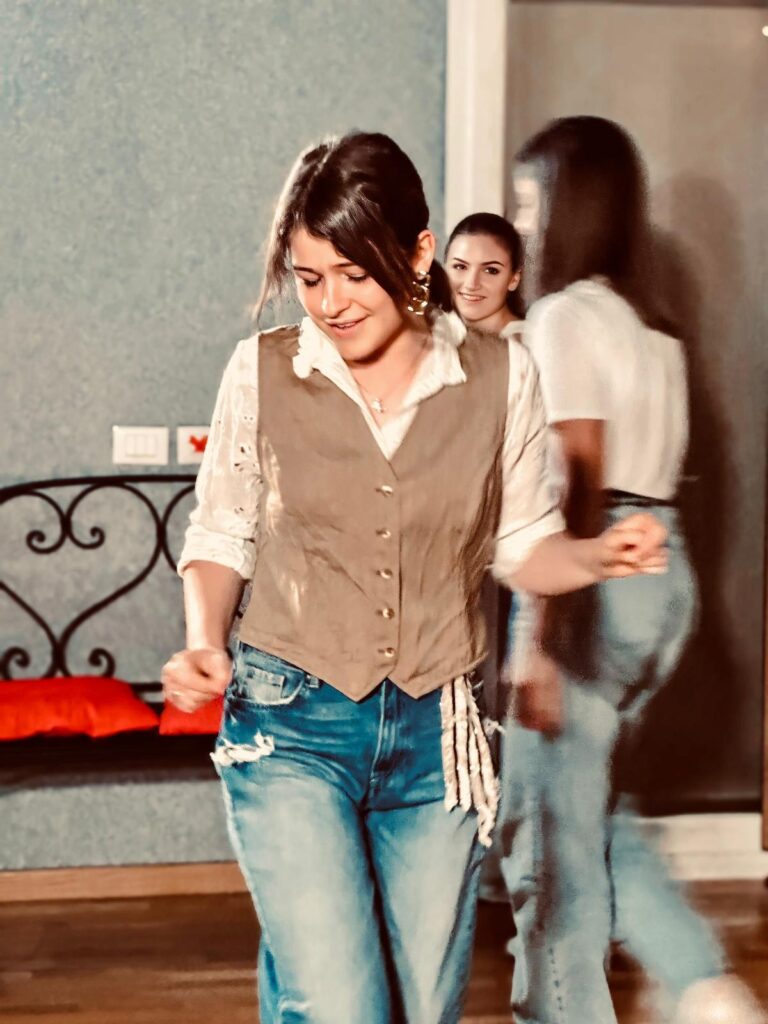 A student in waistcoat and jeans moves in the studio