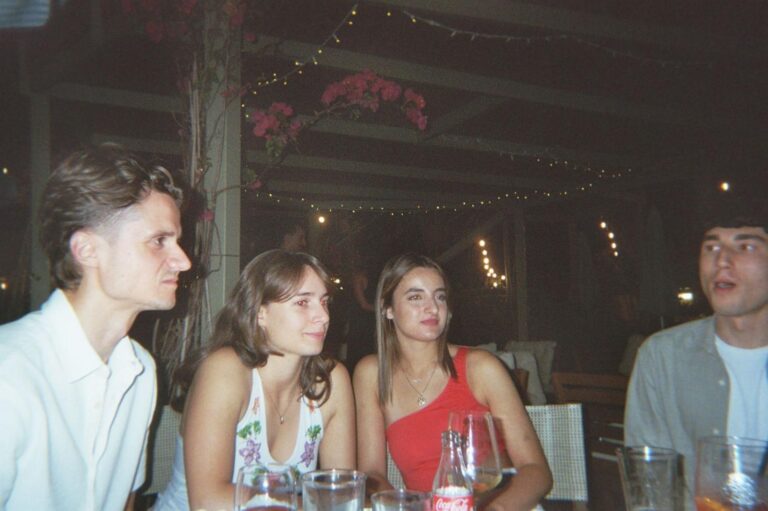Four friends at an outdoor table, in the evening