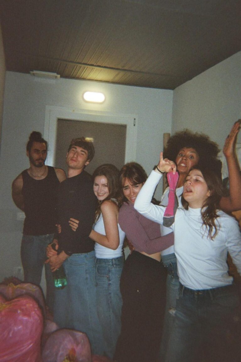 A group of students in the corridor with the pink bags, one holds up a sock