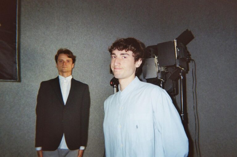 Two students in front of the projector and the spotlight in the studio