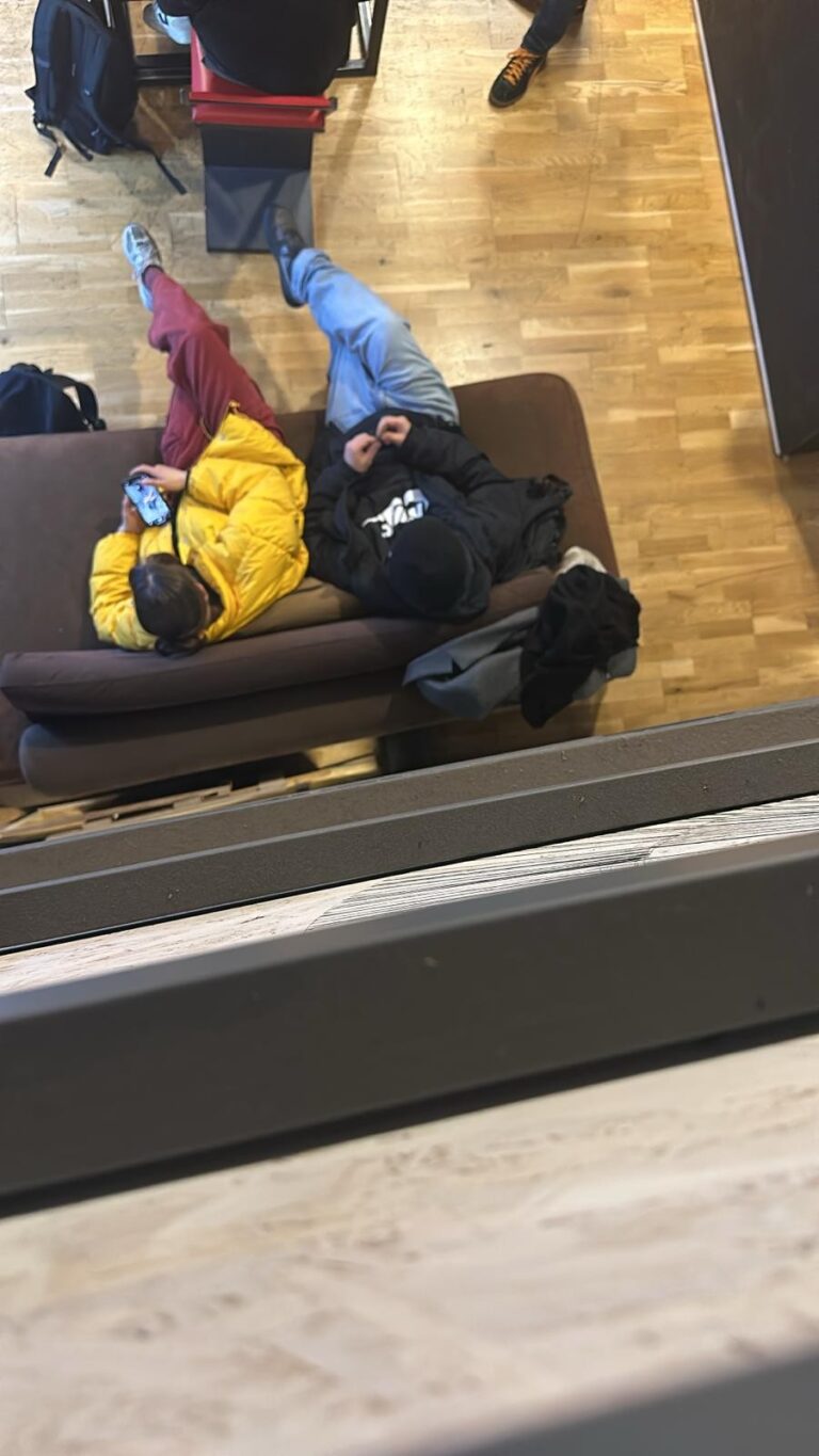 Two students lying on the entrance sofa, seen from above