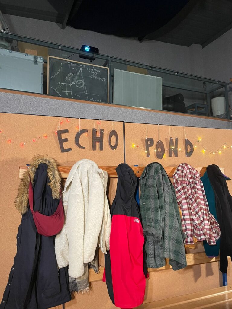 The Almost Maine set with coat hangers, jackets and the blackboard on the mezzanine
