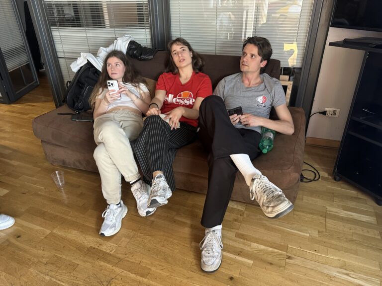 Three students on the brown sofa in the Mob Studios entrance