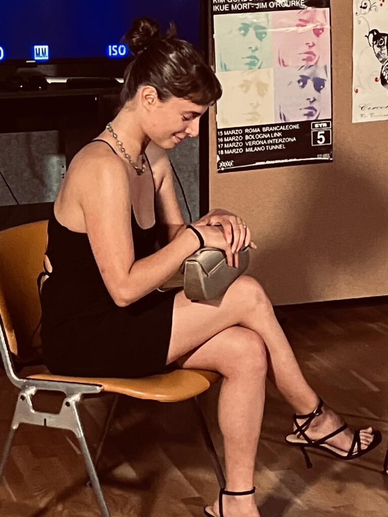 Le Notti di Cabiria: Attrice seduta con pochette profilo