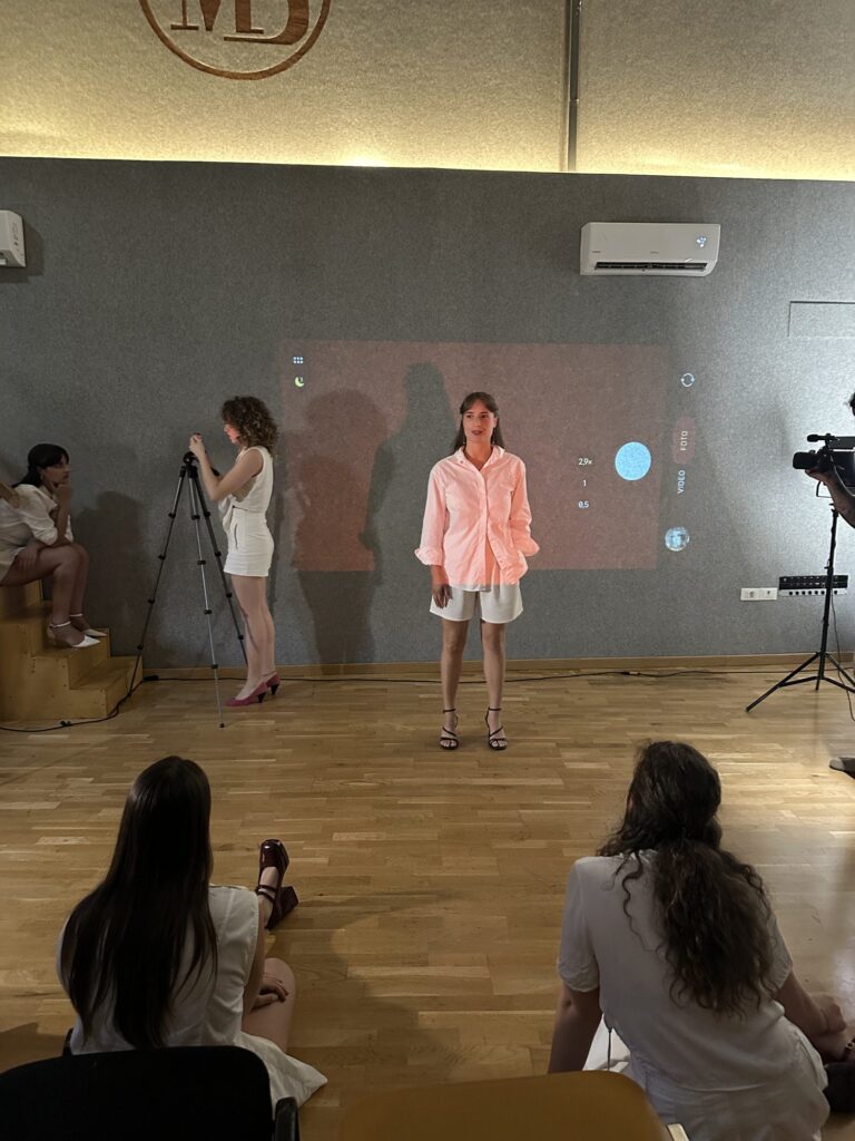 Persona: performer in piedi davanti alla proiezione