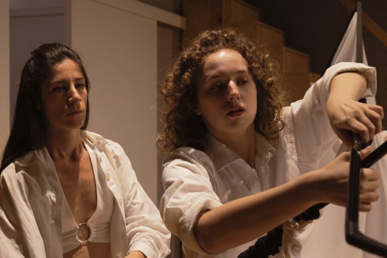 Persona: Due performer in bianco con asta nera