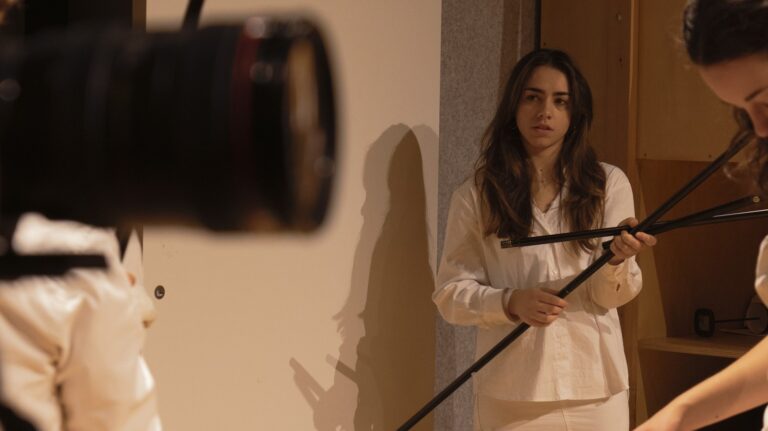 Persona: Performer con aste nere dietro obiettivo camera
