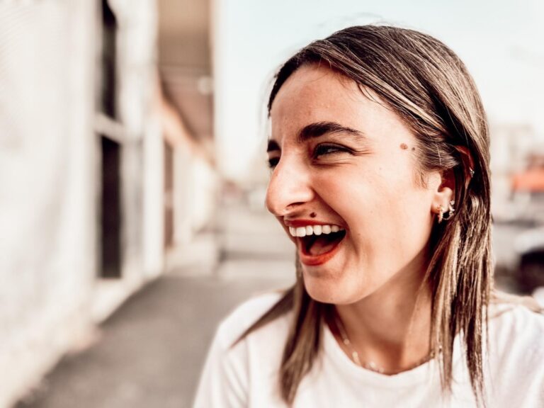 A student laughs in the street, in profile