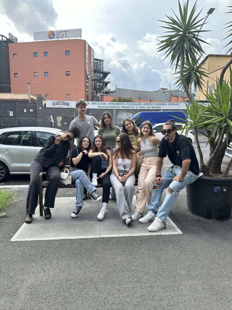 A large group of students posing on the bench outside Mob Studios